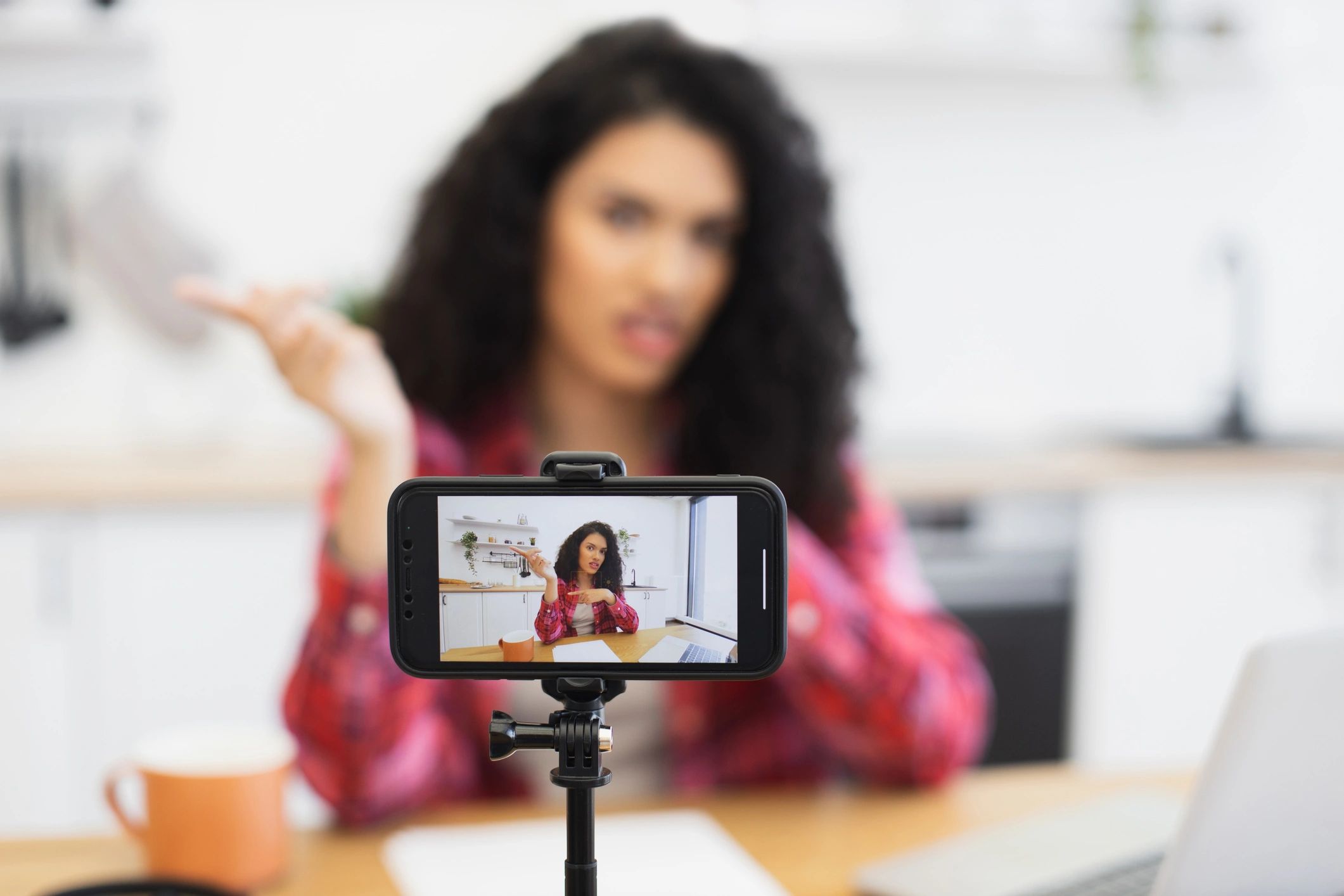 African woman in casual outfit recording video for her blog.